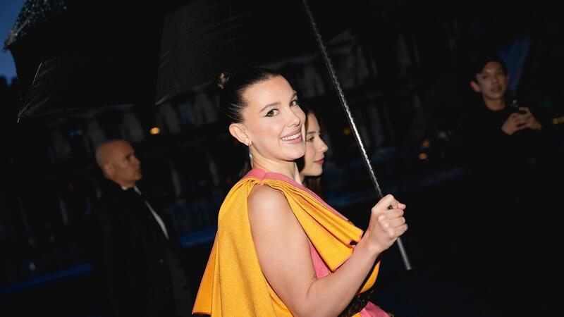 Es regnet, aber Millie Bobby Brown strahlt: Die Schauspielerin kommt Louis-Vuitton-Show.