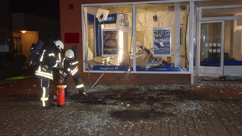 Geldautomat in Harsefeld gesprengt - Tausende Euro liegen auf der Straße Feuerwehrleute kümmern sich um das beschädigte Gebäude