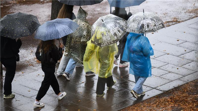 Bilder des Tages Es wird Regen geben! Jugendliche halten Schirme bei Regenwetter in Dresden.
