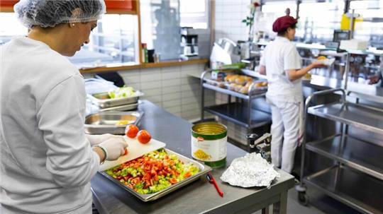 Essen wird aus einer Schulküche ausgegeben.