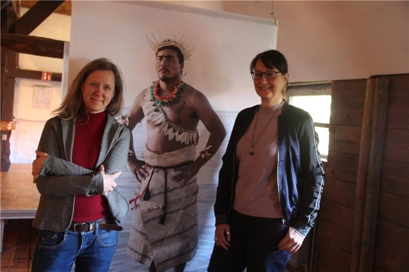 Ethnologin Silja Klepp (links) und Fotografin Barbara Dombrowski mit einem der großformatigen Fotoportraits von Menschen aus fünf Kontinenten, die die Künstlerin derzeit in Agathenburg zeigt. Foto: Michaelis