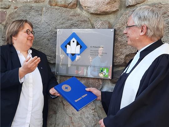 Etwa 50 Kirchen in Niedersachsen tragen das Radwegekirchensignet. Antje Wachtmann hat es mit Pastor Andreas Hellmich angebracht. Fotos: Fehlbus