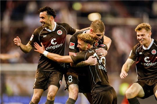 FC St. Pauli - FC Schalke 04 im Millerntor-Stadion. Spieler vom FC St. Pauli bejubeln den Treffer zum 2:1 durch Carlo Boukhalfa (M). Foto: Philipp Szyza/dpa
