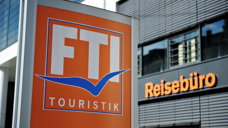 Ein FTI-Firmenschild steht vor einem Reisebüro.