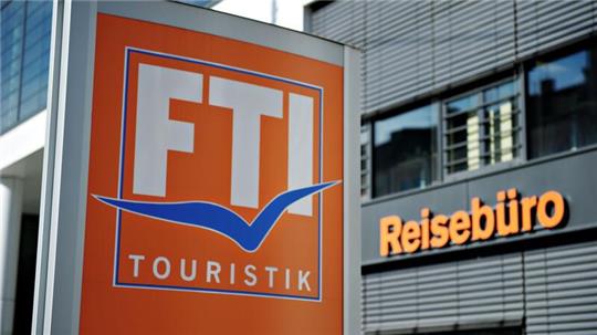 Ein FTI-Firmenschild steht vor einem Reisebüro.