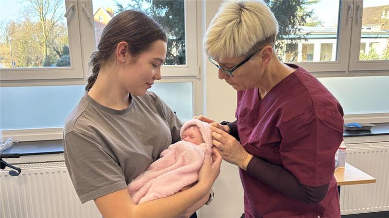 Fachpraxislehrkraft Claudia Bertram erklärt einer Pflegeschülerin, wie Babys richtig versorgt werden.