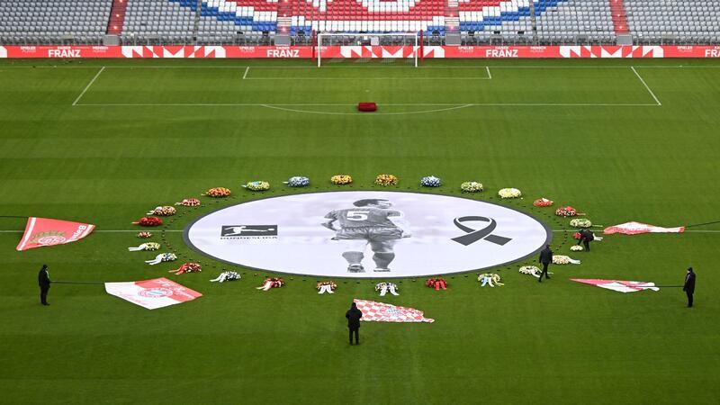 Berührende Worte von Hoeneß: „Franz, du fehlst mir sehr“ Fahnen von FCB-Fanclubs liegen neben einem überlebensgroßen Beckenbauer-Bild im Mittelkreis der Allianz Arena.