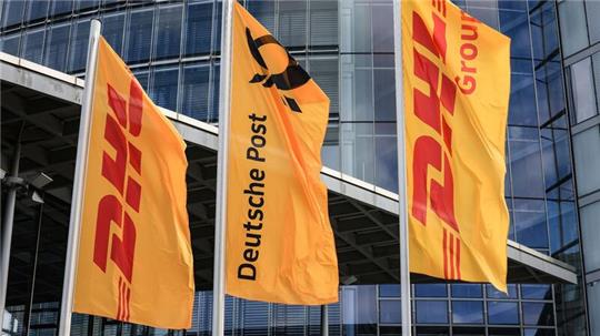 Fahnen von Post und DHL wehen vor der Zentrale der DHL Group - Deutsche Post in Bonn.