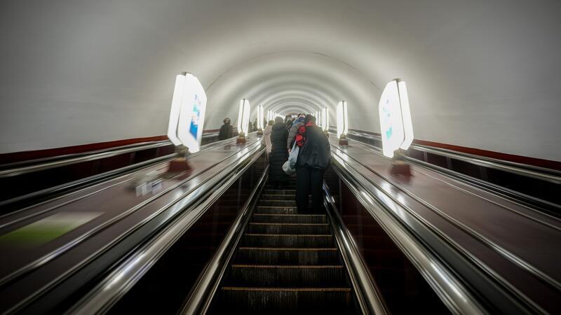 Fahrgäste stehen am Morgen in der Metrostation Universytet in der ukrainischen Hauptstadt auf den langen Rolltreppen Richtung Ausgang.