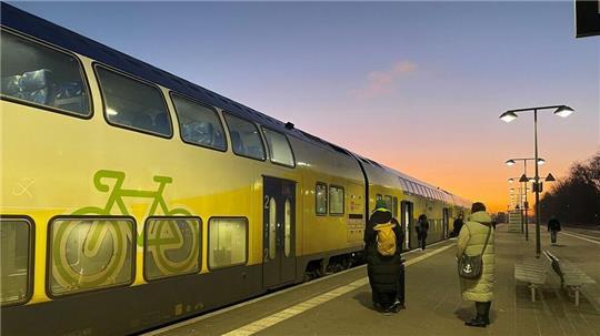Fahrgäste warten geduldig auf den verspäteten RE5 am Bahnhof.