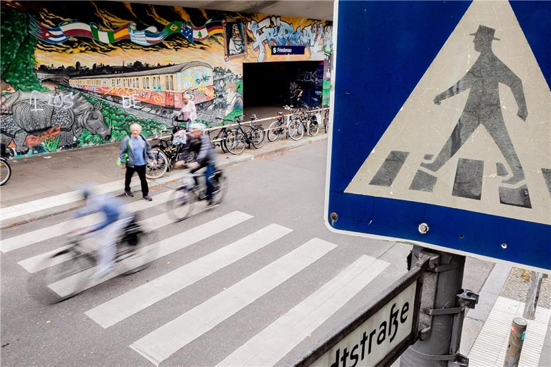 Fahrradfahrer und ein Fußgänger überqueren einen Zebrastreifen. Foto: Christoph Soeder/dpa