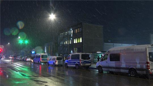 Fahrzeuge der Ermittler und Spurensicherung stehen vor einem Gebäude der Zeugen Jehovas in Hamburg. 