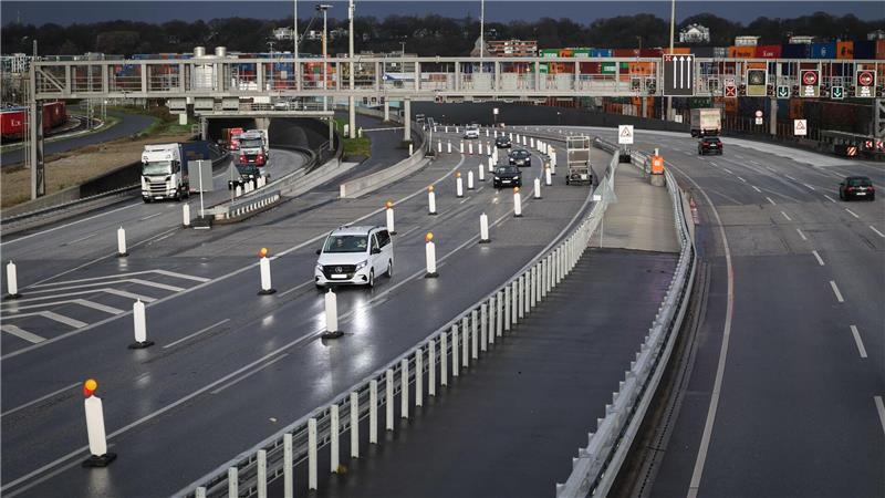 Fahrzeuge fahren am Südportal aus und in die Röhren des Elbtunnels.