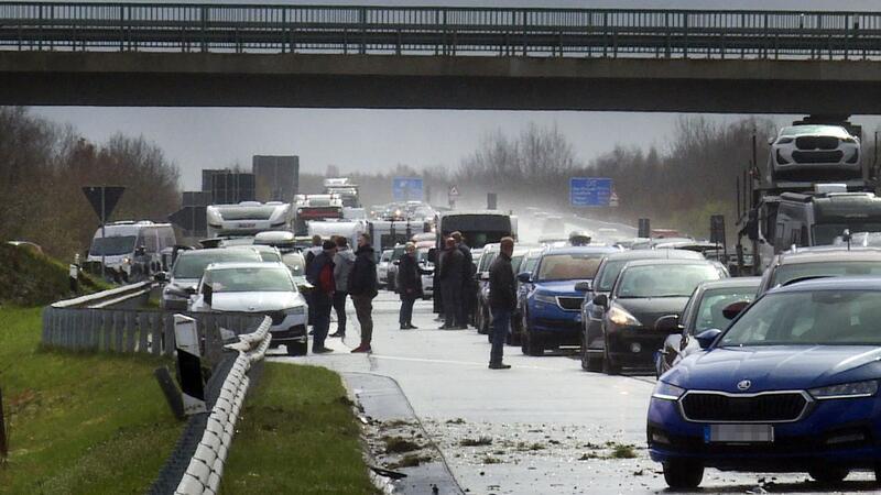 Fahrzeuge und Menschen stehen nach mehreren Unfällen auf der Fahrbahn der A31.