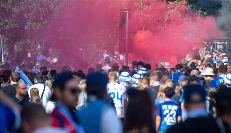 Fans des FC Hansa Rostock und des FC St. Pauli zündeln mit Bengalischen Feuern. Foto: Stefan Sauer/dpa