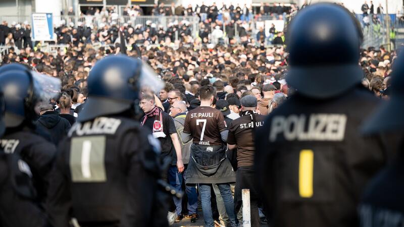 Schnabel vor Stadt-Derby: Stadien keine „rechtsfreien Räume“ Fans des FC St. Pauli gehen ins Stadion, im Vordergrund sind Polizeibeamte zu sehen.