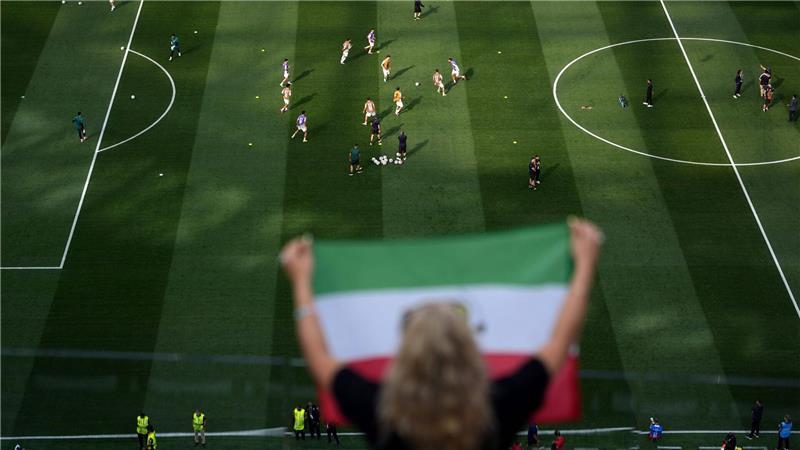 Fans jubeln, während sich die iranischen Spieler vor dem WM-Spiel gegen Neuseeland aufwärmen.
