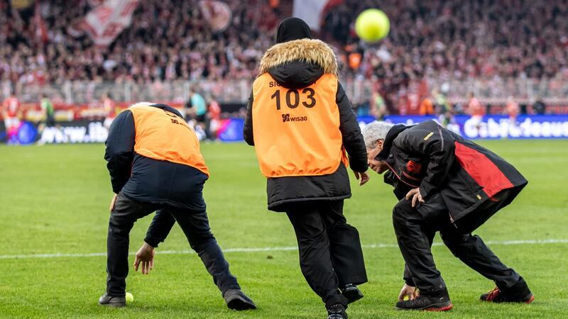 Machtprobe mit Kalkül: Spielabbruch nur eine Frage der Zeit Fans vom VfL Wolfsburg werfen Tennisbälle auf das Spielfeld.