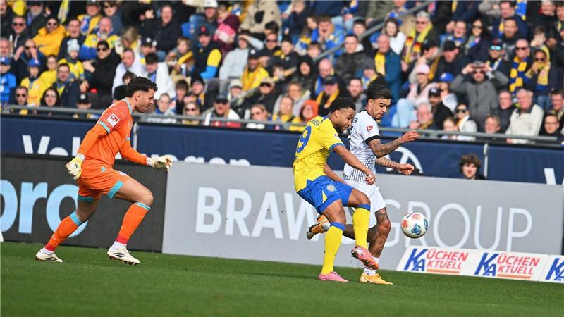 Fast das 1:0 für Münster: Oliver Batista-Meier (r) nutzt einen Fehler der beiden Braunschweiger Elhan Kastrati (l) und Leon Bell Bell, spielt den Ball dabei aber mit dem Arm.