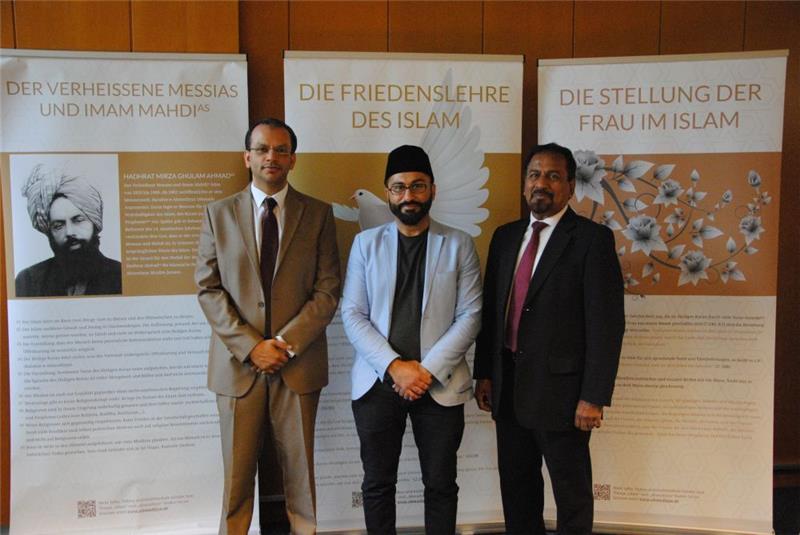 Fazal Ahmad, Pressesprecher der Ahmadiyya-Gemeinde Hamburg, und Zeeshan und Nasir Rajput von der Stader Gemeinde vor einem kleinen Teil der Ausstellung über den Islam . Foto: Stief