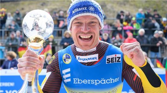 Felix Loch jubelt mit der Kristallkugel für den Gesamtweltcupsieg.