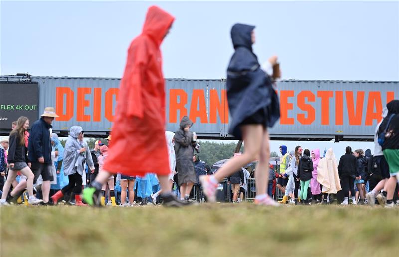Deichbrand-Festival: Mega-Panne bei Tokio-Hotel-Auftritt Festival-Besucher ziehen mit Regen-Ponchos übers Gelände.