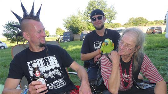 Festival-Freaks: Micha (49, links) aus Bad Bevensen mit Irokesen-Pracht und Schottenrock grillt mit Ibbi (65, rechts) aus Hamburg. Papagei Birdie begleitet Ibbi seit 46 Jahren. René (30) kommt aus Hollenbeck.