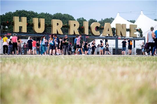 Festivalbesucher gehen 2022 am Haupteingang des Hurricane Festivals entlang.