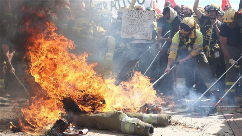 Bilder des Tages Feuer und Flamme: Spanische Feuerwehrleute demonstrieren für besseren Arbeitsbedingungen. In Spanien gab es in den letzten Wochen verheerende Waldbrände, bei denen mindestens ein Feuerwehrmann ums Leben kam.