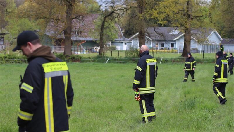 Feuerwehr und Polizei ziehen am Freitagvormittag in Estorf von Straße zu Straße, betreten auch Grundstücke.