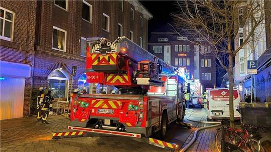 Feuerwehreinsatz im Alten Deichweg: Feuerwehrfahrzeuge sichern das Wohngebäude mit Café in Cuxhaven, während die Ermittlungen zur Rauchentwicklung fortgesetzt werden.