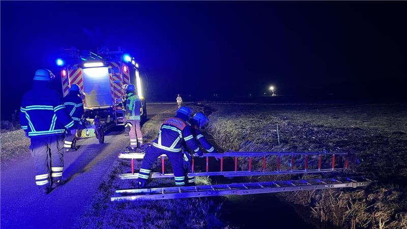 Feuerwehrleute aus Wiepenkathen legen Leitern über die Gräben in den Schwingewiesen.