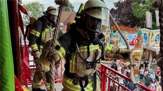 Feuerwehrleute der Freiwilligen Feuerwehr Neukloster gehen zur Überraschung der Besucher auf dem Pfingstmarkt Neukloster unter Atemschutz durch das Laufgeschäft Feueralarm - alles nur zum Spaß.