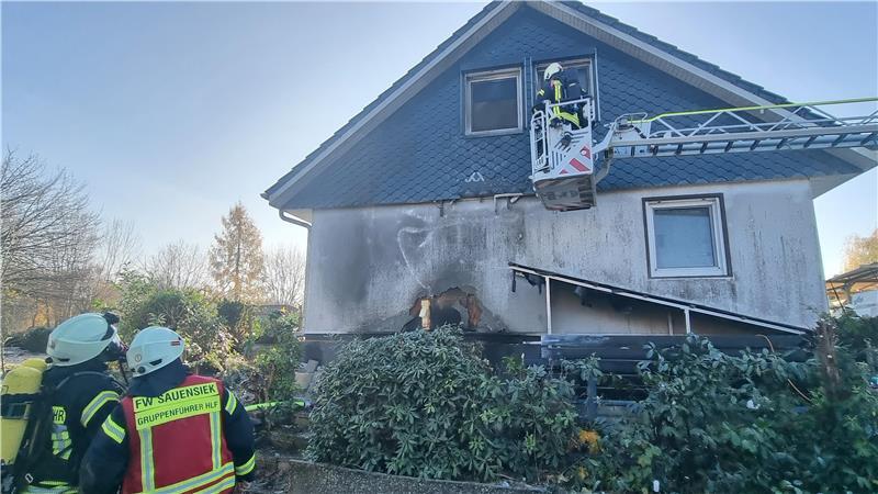Feuerwehrleute entfernen die Fassade, um das Dach zu kontrollieren.
