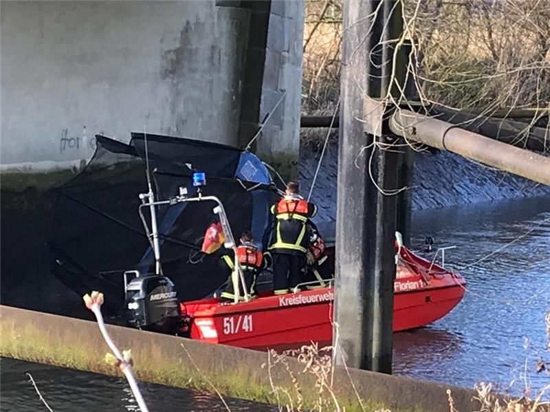 Feuerwehrleute fischen das Trampolin am Alten Lühe-Sperrwerk aus dem Fluss. Foto Brandt