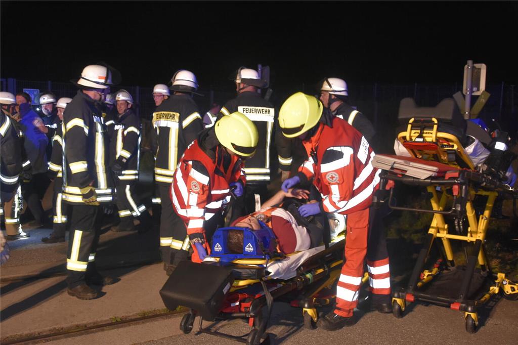 Feuerwehrleute haben zwei "Unfallopfer" auf Tragen gelegt.