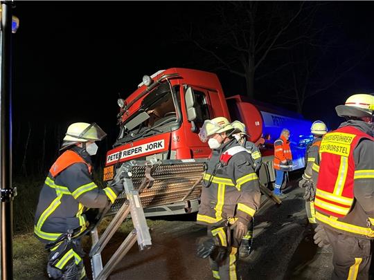 Feuerwehrleute holen den verletzten Fahrer aus der Zugmaschine.