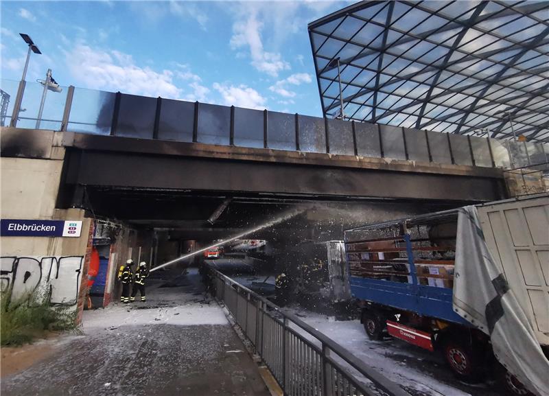 Feuerwehrleute löschen am Bahnhof Elbbrücken einen brennenden Lkw. Foto: Hutchings/dpa