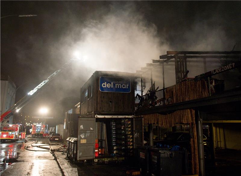 Feuerwehrleute löschen am Donnerstagabend in Hamburg den Beachclub „Hamburg del Mar“ . Der Hamburger Strandclub neben den Landungsbrücken ist ausgebrannt. Foto Heimken/dpa