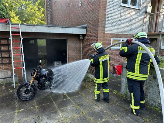 Feuerwehrleute löschen das brennende Motorrad. Foto: Dehmlow