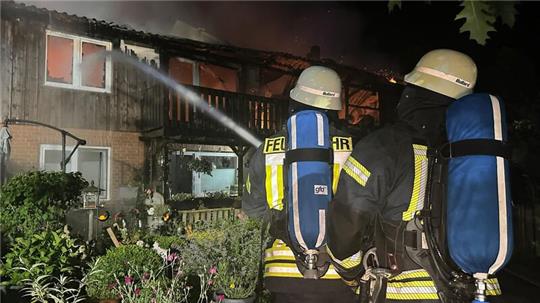 Feuerwehrleute löschen den Brand in einem Mehrfamilienhaus in Kükels. 