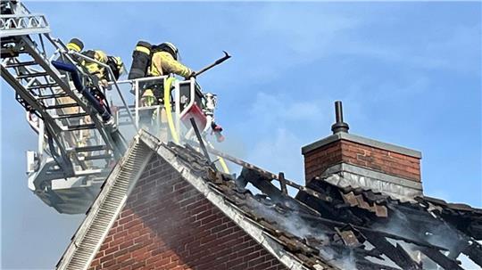 Feuerwehrleute löschen den Dachstuhlbrand in Nindorf.