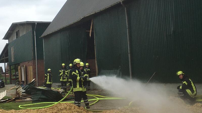 Feuerwehrleute löschen einen Scheunenbrand.