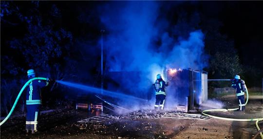 Feuerwehrleute löschen den brennenden Container in Himmelpforten.