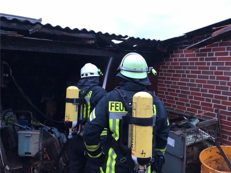 Carport in Mulsum brennt nach Blitzschlag Feuerwehrleute löschen ein brennendes Carport in Mulsum. Foto: Klempahn/Feuerwehr