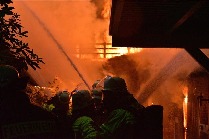 Feuerwehrleute löschen ein brennendes Reetdachhaus in Düdenbüttel. Fotos: Beneke