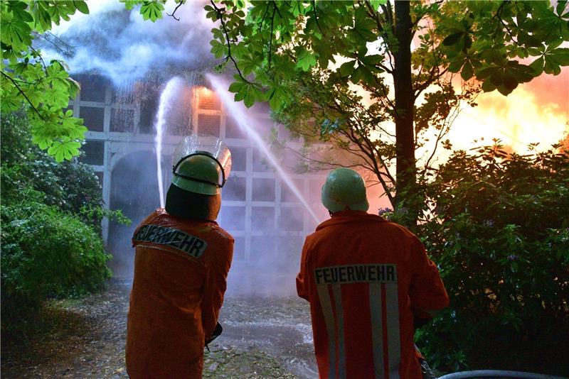 Feuerwehrleute löschen ein brennendes Reetdachhaus in Düdenbüttel. Fotos: Beneke