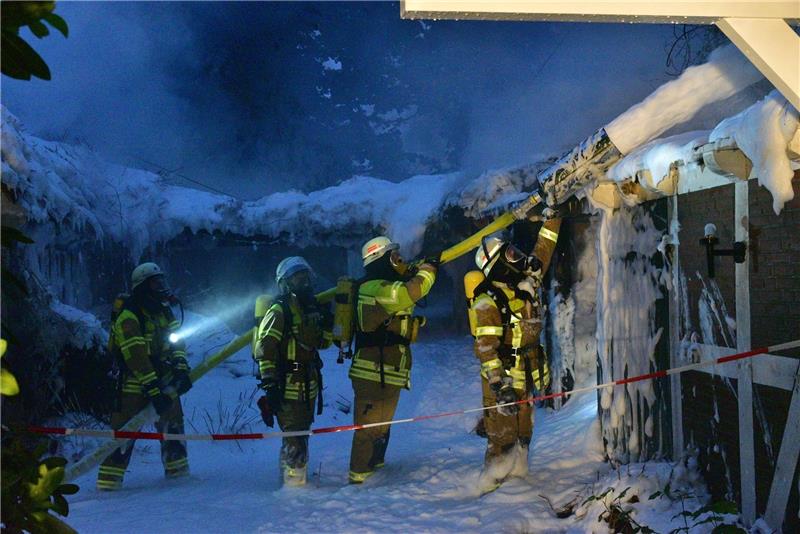 Feuerwehrleute löschen ein brennendes Reetdachhaus in Düdenbüttel. Fotos: Beneke