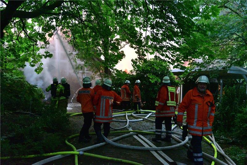 Feuerwehrleute löschen ein brennendes Reetdachhaus in Düdenbüttel. Fotos: Beneke