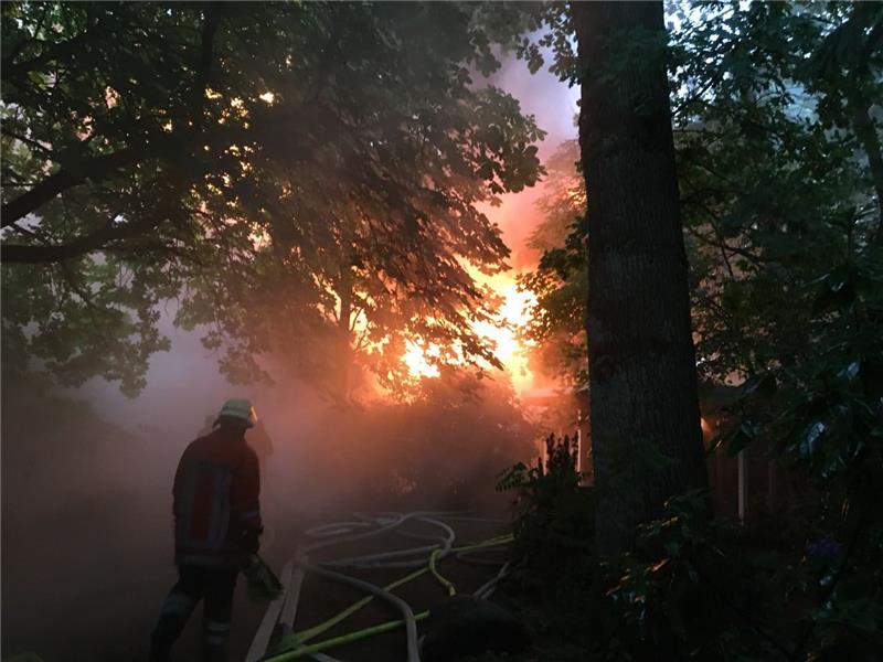 Feuerwehrleute löschen ein brennendes Reetdachhaus in Düdenbüttel. Fotos: Beneke
